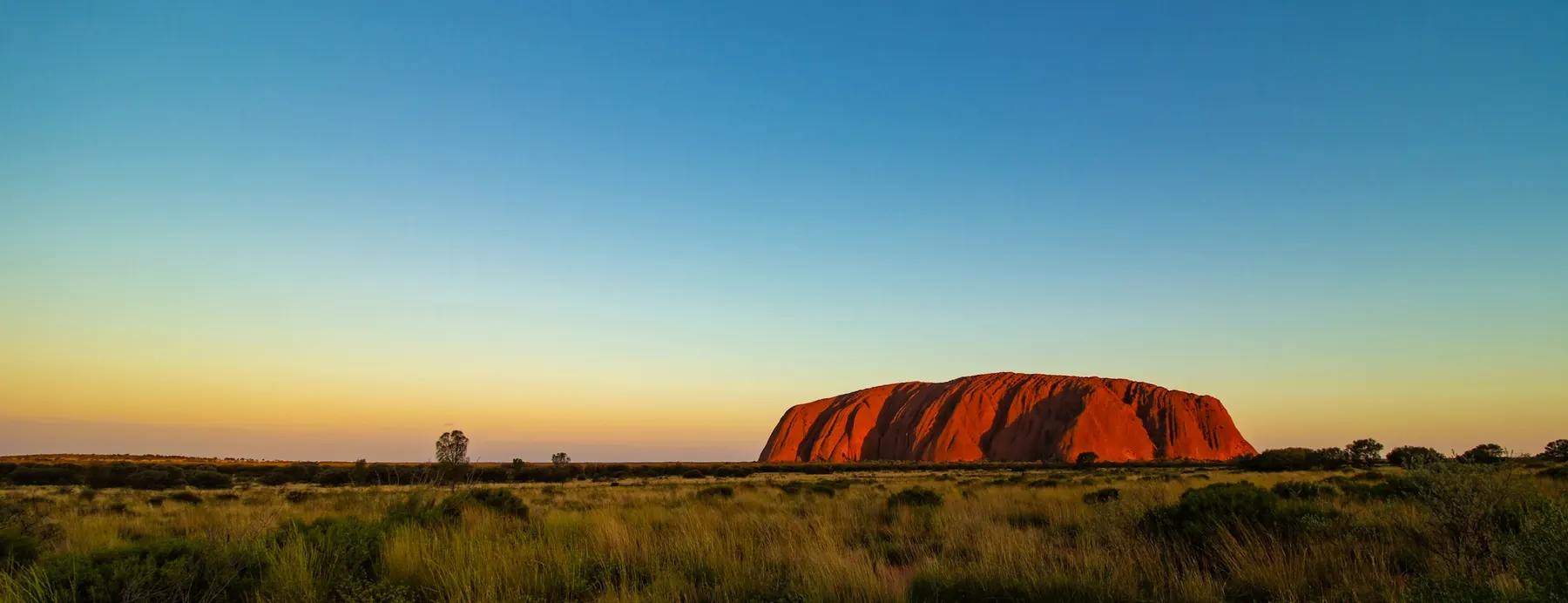 Uluru at dusk under a clear desert sky